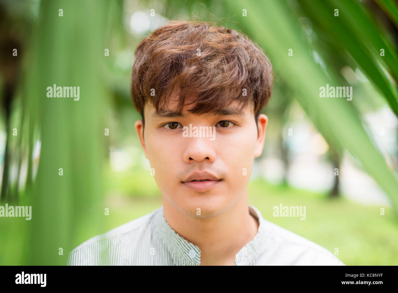 Porträt eines asiatischen jungen Mann stand draußen Stockfoto