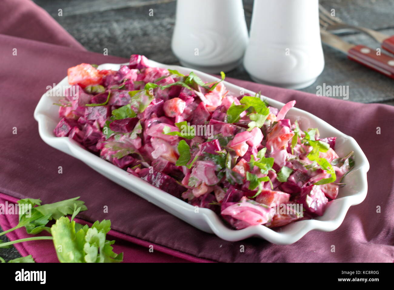 Salat mit gekochte rote Bete, Kartoffeln, Gurken, Zwiebeln in eine weiße Platte auf einer Textur Hintergrund Stockfoto