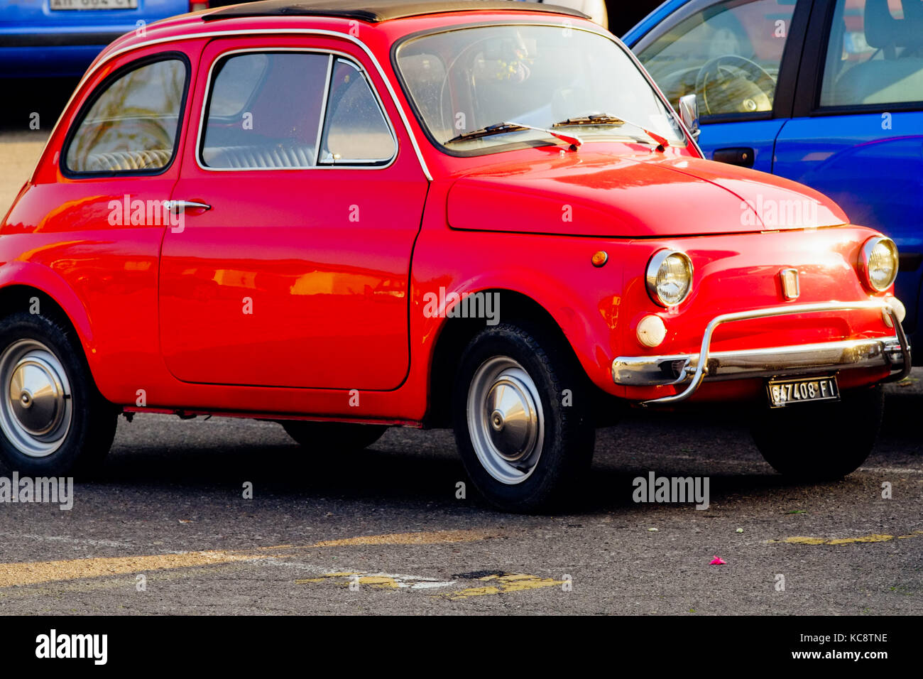 Rot Fiat 500 in der Nähe von Blue Autos auf der Straße geparkt. Classic vintage Modell. Florenz, Italien Stockfoto