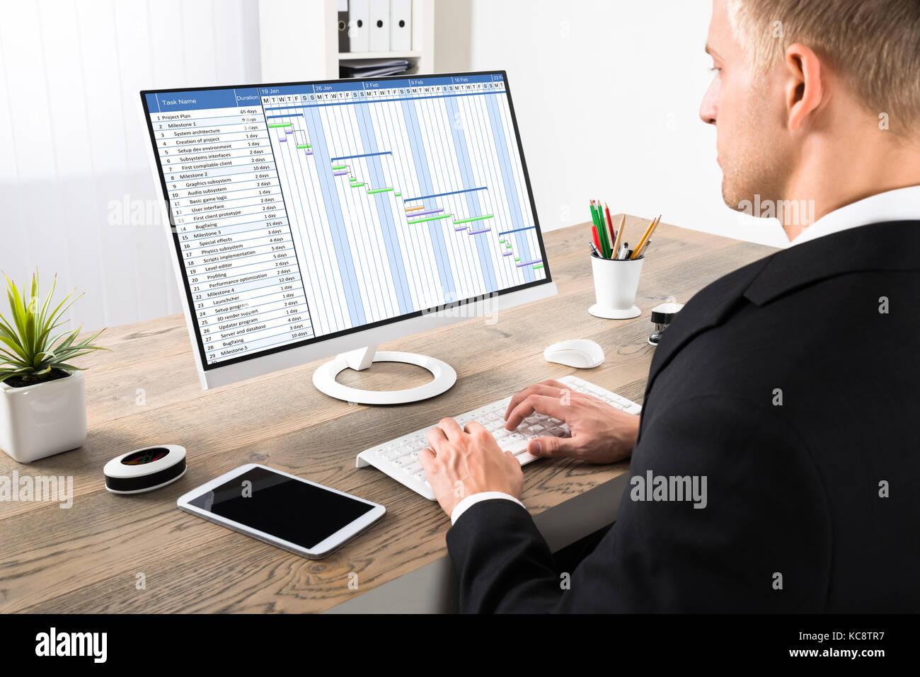 Junge Unternehmer auf Gantt-diagramm Arbeiten am Computer im Büro Stockfoto