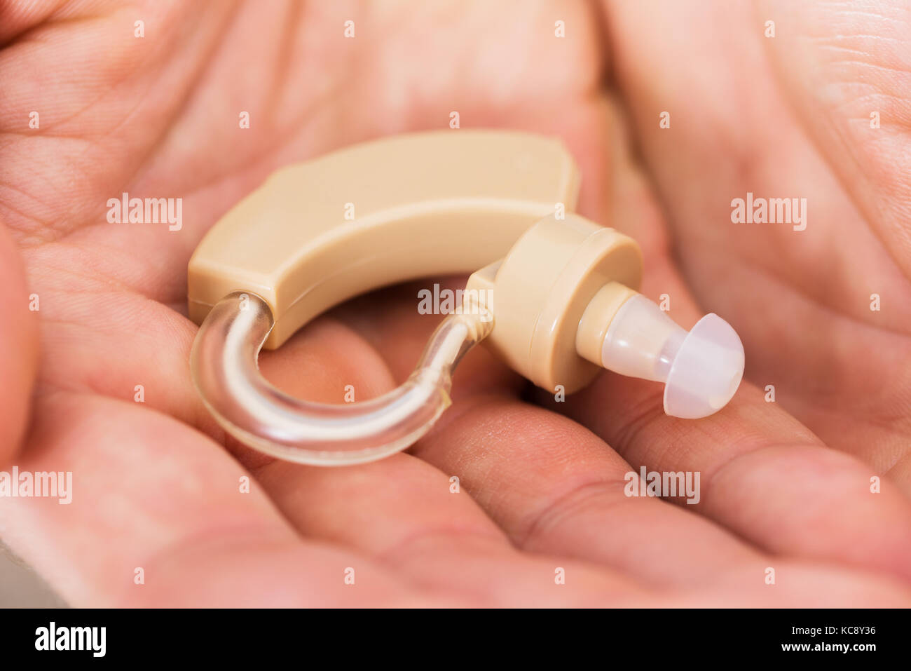 In der Nähe von Hörgeräten auf Person Palm Stockfoto