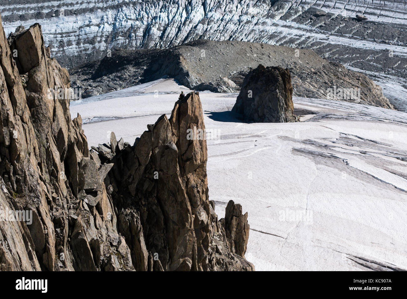 Einsame Kletterer auf der Oberseite des Berges Pinnacle mit Blick auf den Glacier du Argentiere im Sommer Stockfoto