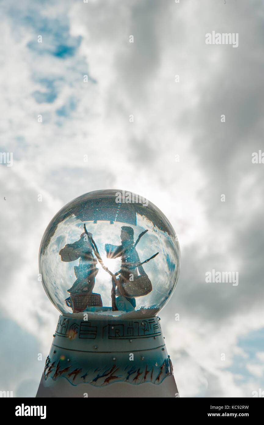 Spielzeug Paar in einem Glas Kugel mit blauem Himmel und Sonne Stockfoto
