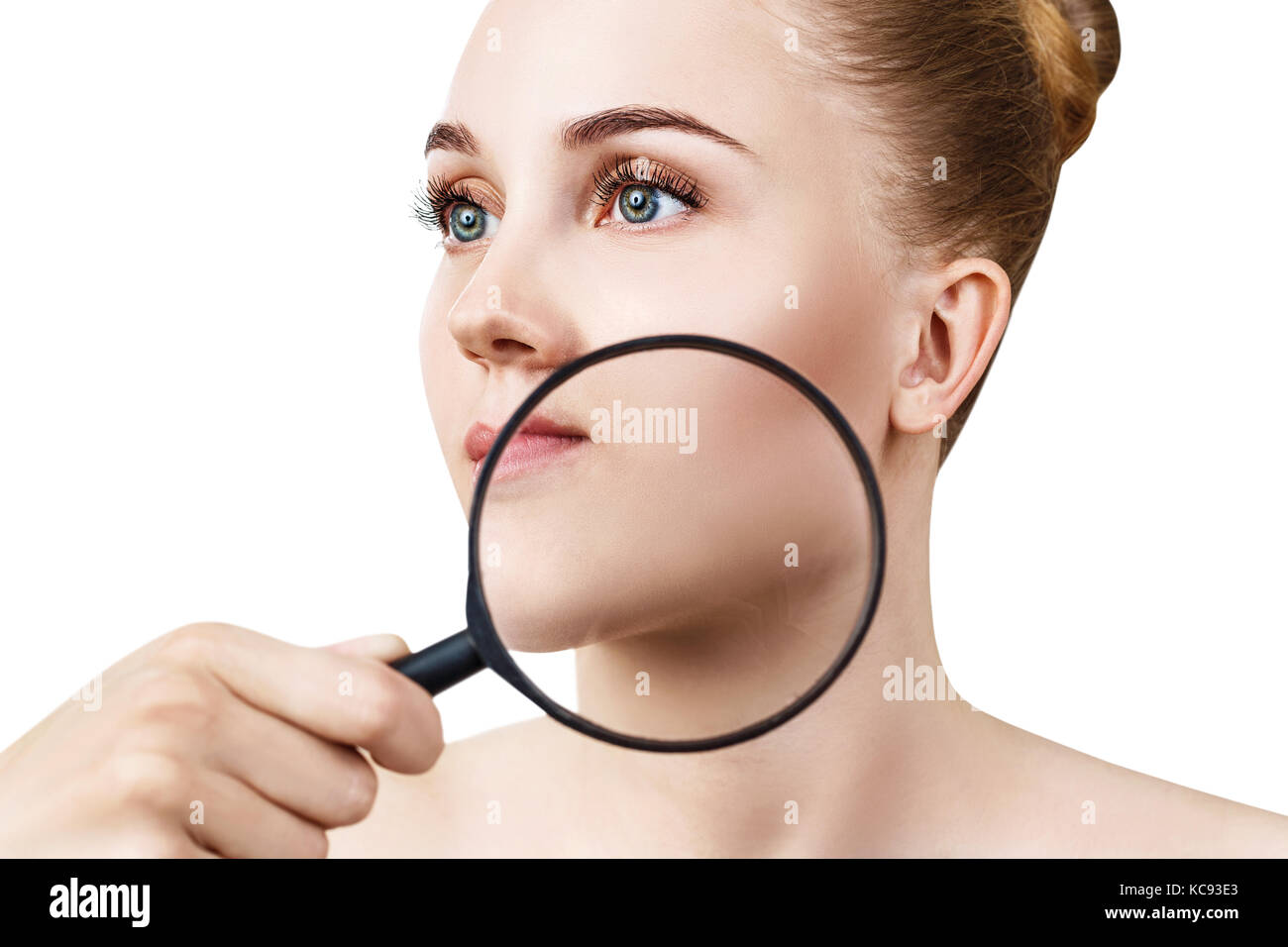 Junge Frau mit Lupe prüfen Haut. Stockfoto