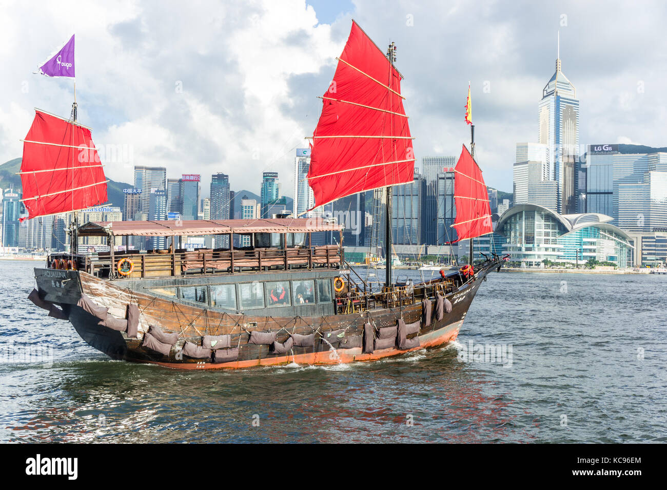 Iconic aqualuna Schiff mit leuchtend roten Segel im Victoria Harbour in Hong Kong SAR Stockfoto