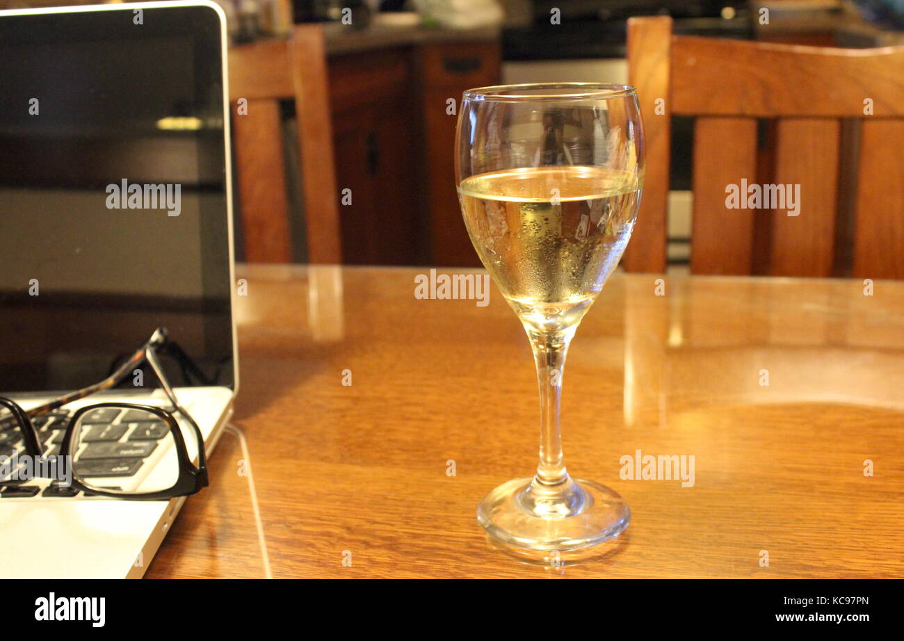 Tabelle mit Wein, Gläser, und Computer Stockfoto