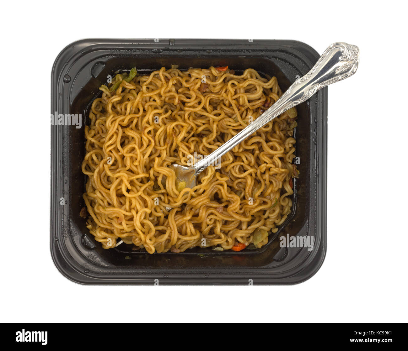 Blick von oben auf eine Portion Rindfleisch aromatisiert Ramen Nudeln mit einer Gabel in einem Schwarzen im Mikrowellengerät aufwärmbare Fach auf einem weißen Hintergrund. Stockfoto