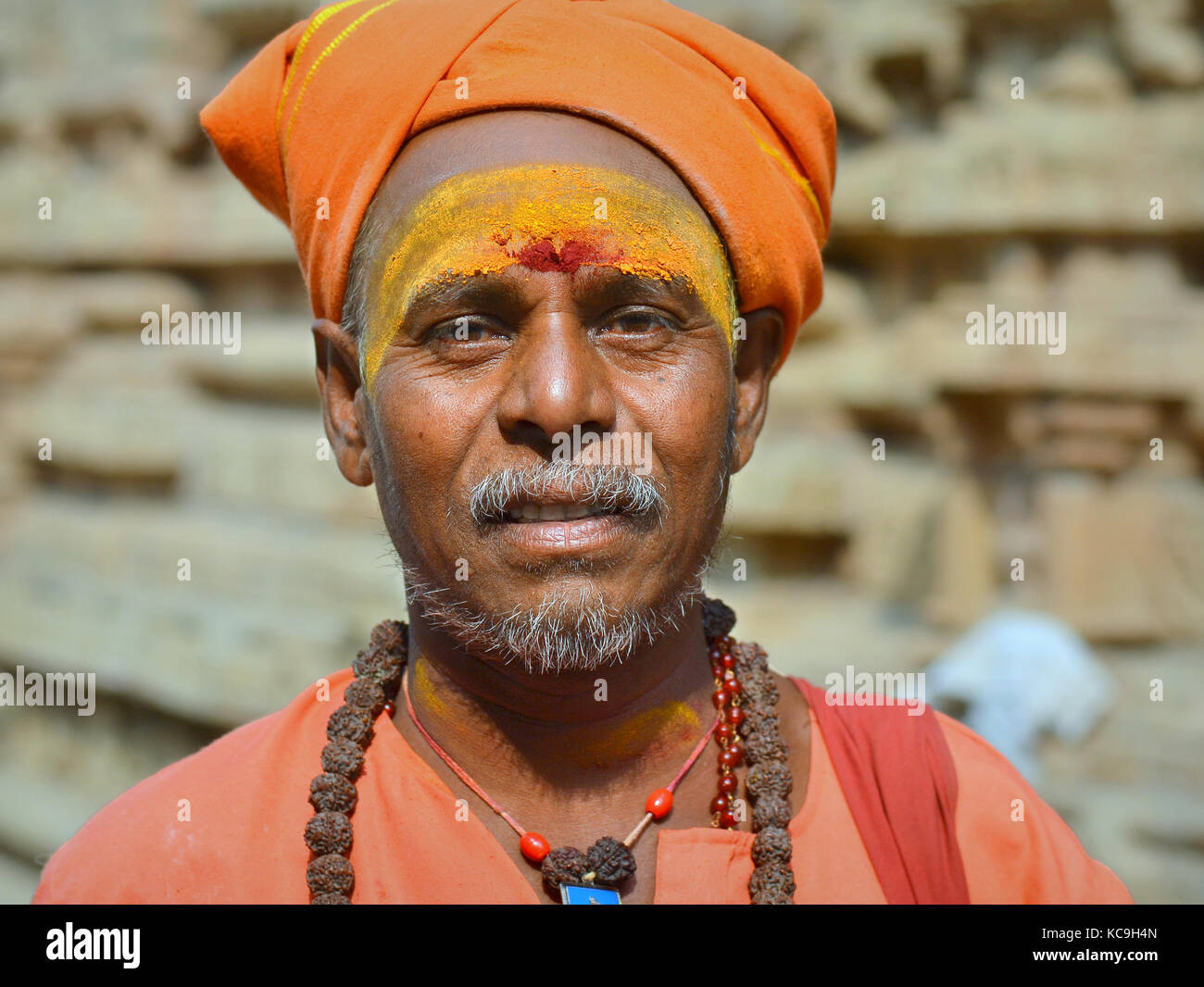 Shaivite-Sadhu mittleren Alters mit orangefarbenem Turban, rotem Tilaka-Zeichen und gelber Sandelholzpaste auf der Stirn, Rudraksha-Perlen um den Hals Stockfoto