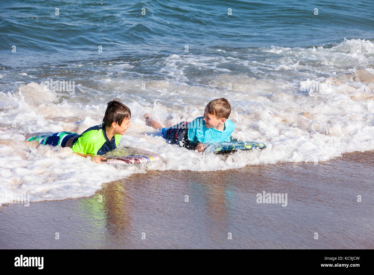 Avon, Outer Banks, North Carolina, USA. Pre-Jungs im Teenageralter im Atlantik surfen mit Boogie Boards. Stockfoto