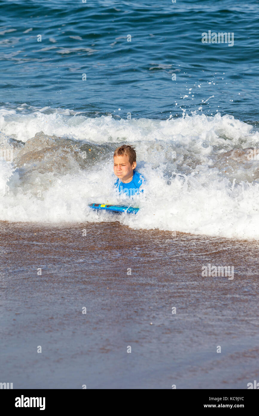 Avon, Outer Banks, North Carolina, USA. Pre-Jungs im Teenageralter im Atlantik surfen auf Ihren Boogie Boards. Stockfoto