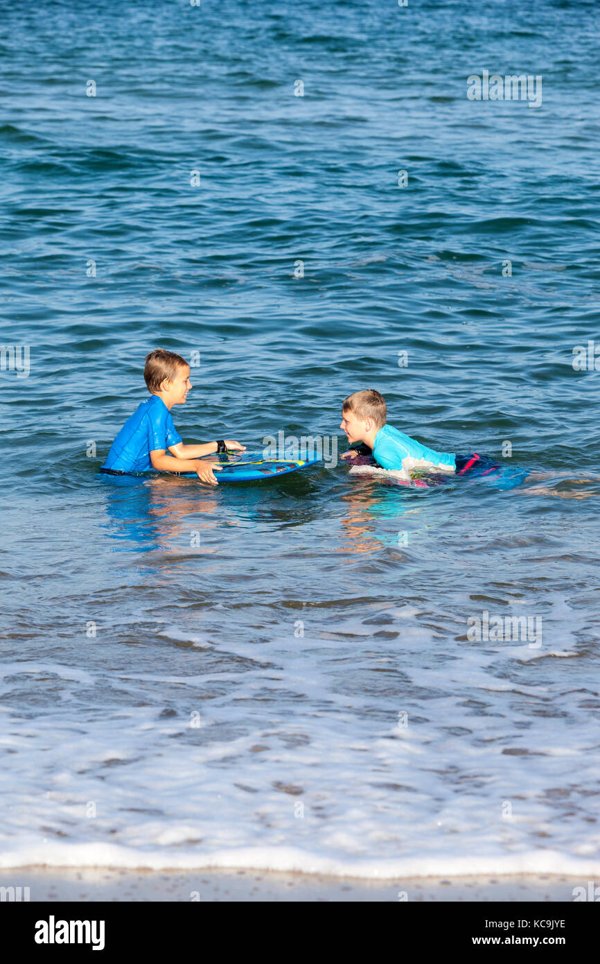 Avon, Outer Banks, North Carolina, USA. Zwei Jungen im Teenageralter mit ihren Boogie Boards auf einem Atlantic Beach. Stockfoto
