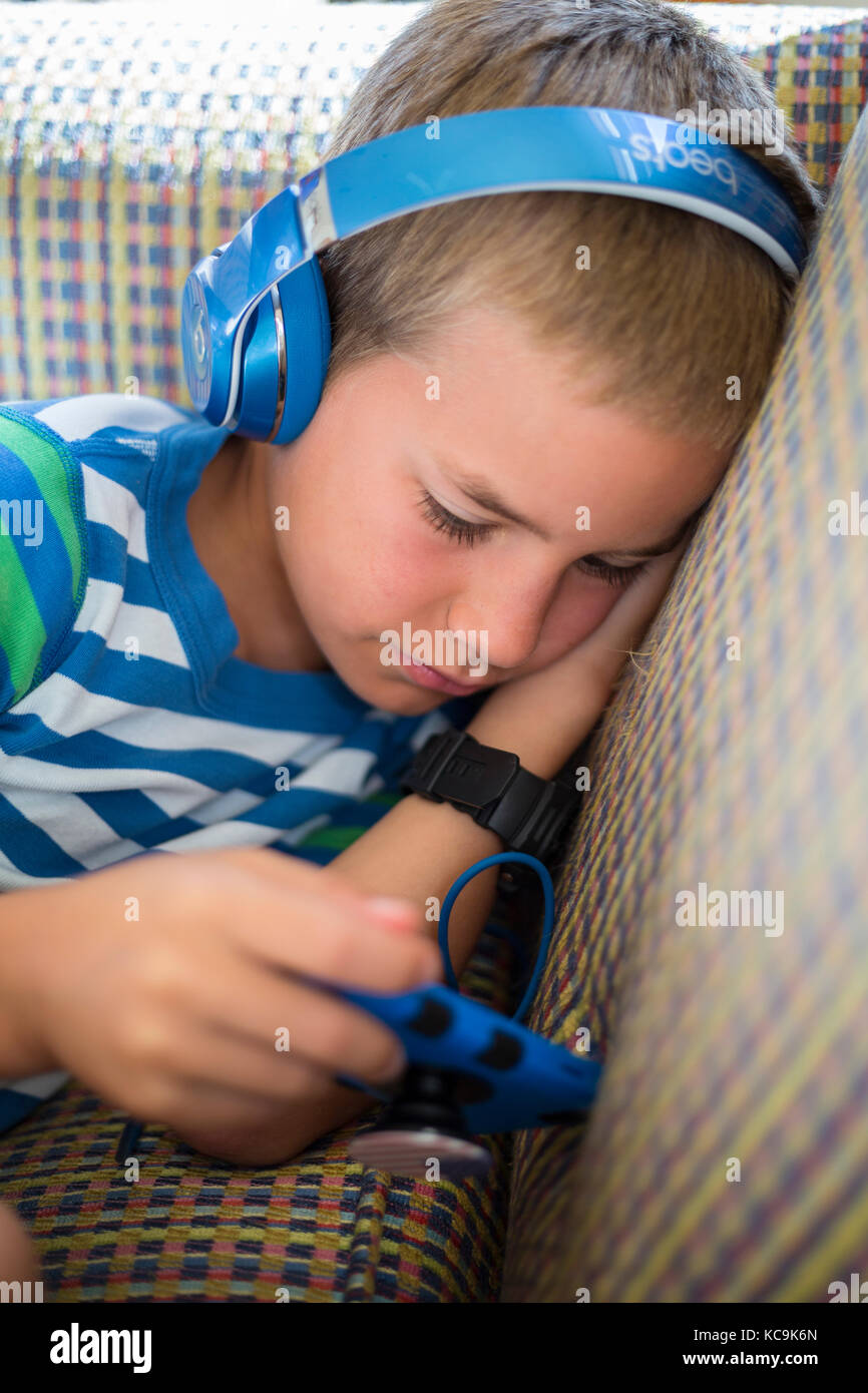 Avon, Outer Banks, North Carolina, USA. Junge amerikanische Junge spielt mit seiner mobilen Spielkonsole. Stockfoto