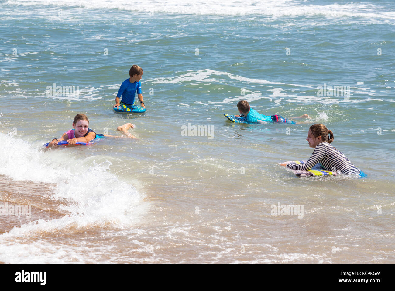 Avon, Outer Banks, North Carolina, USA. Kinder im Atlantik surfen. Stockfoto