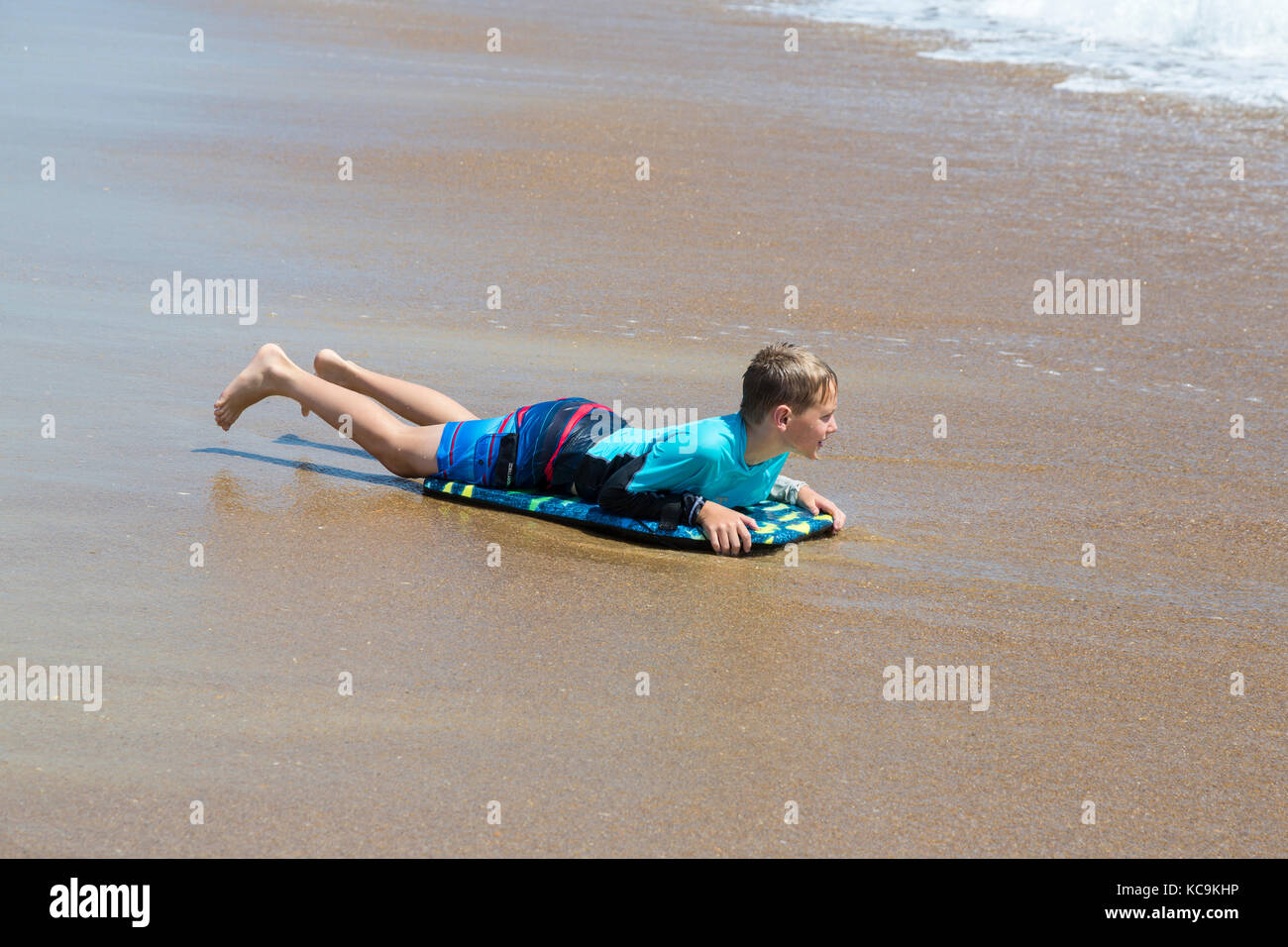 Avon, Outer Banks, North Carolina, USA. Junge geerdet am Strand mit seinem Boogie Board. Stockfoto
