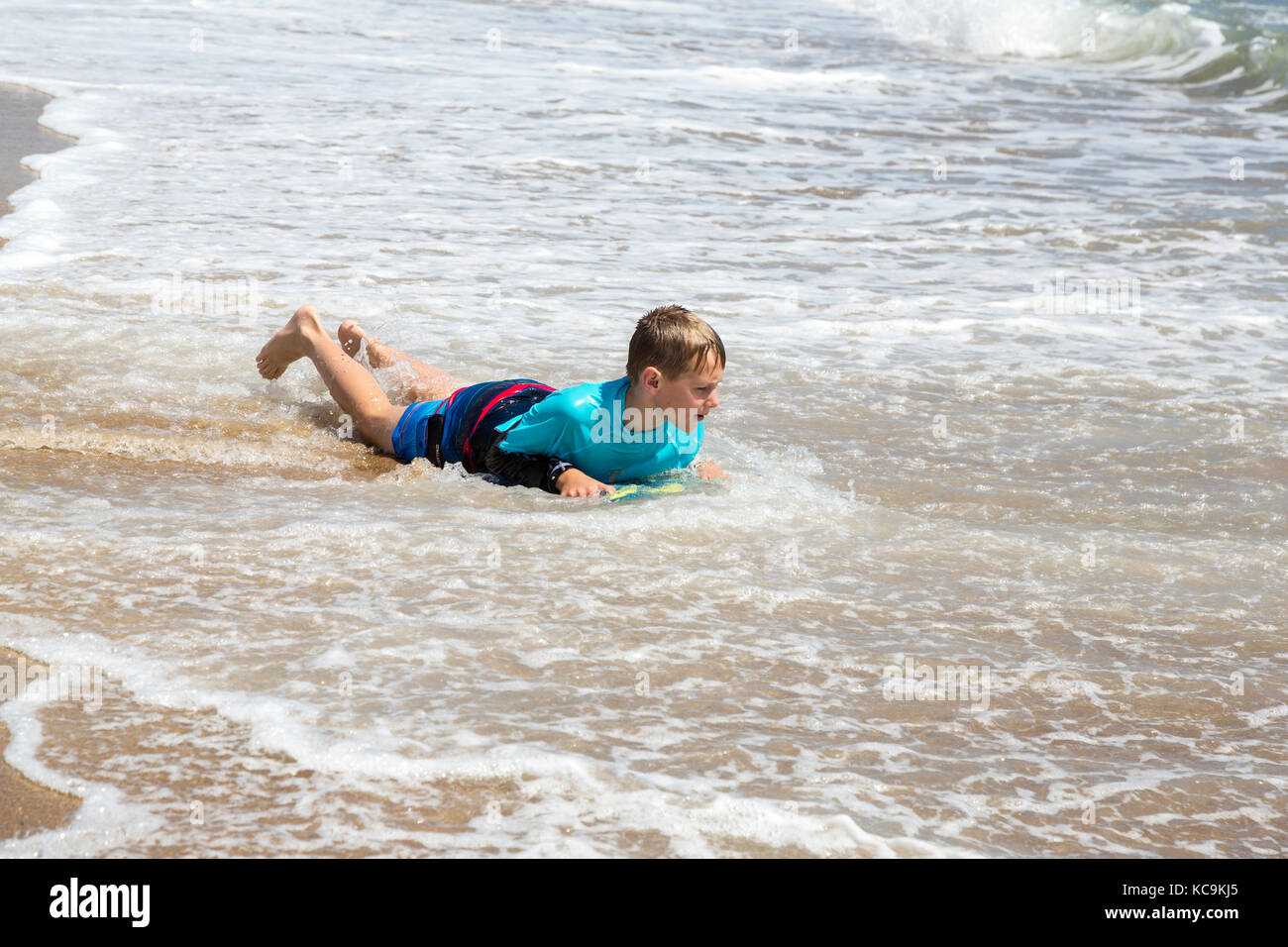 Avon, Outer Banks, North Carolina, USA. Kinder in der Brandung. Junge am Strand mit seinem Boogie Board. Stockfoto