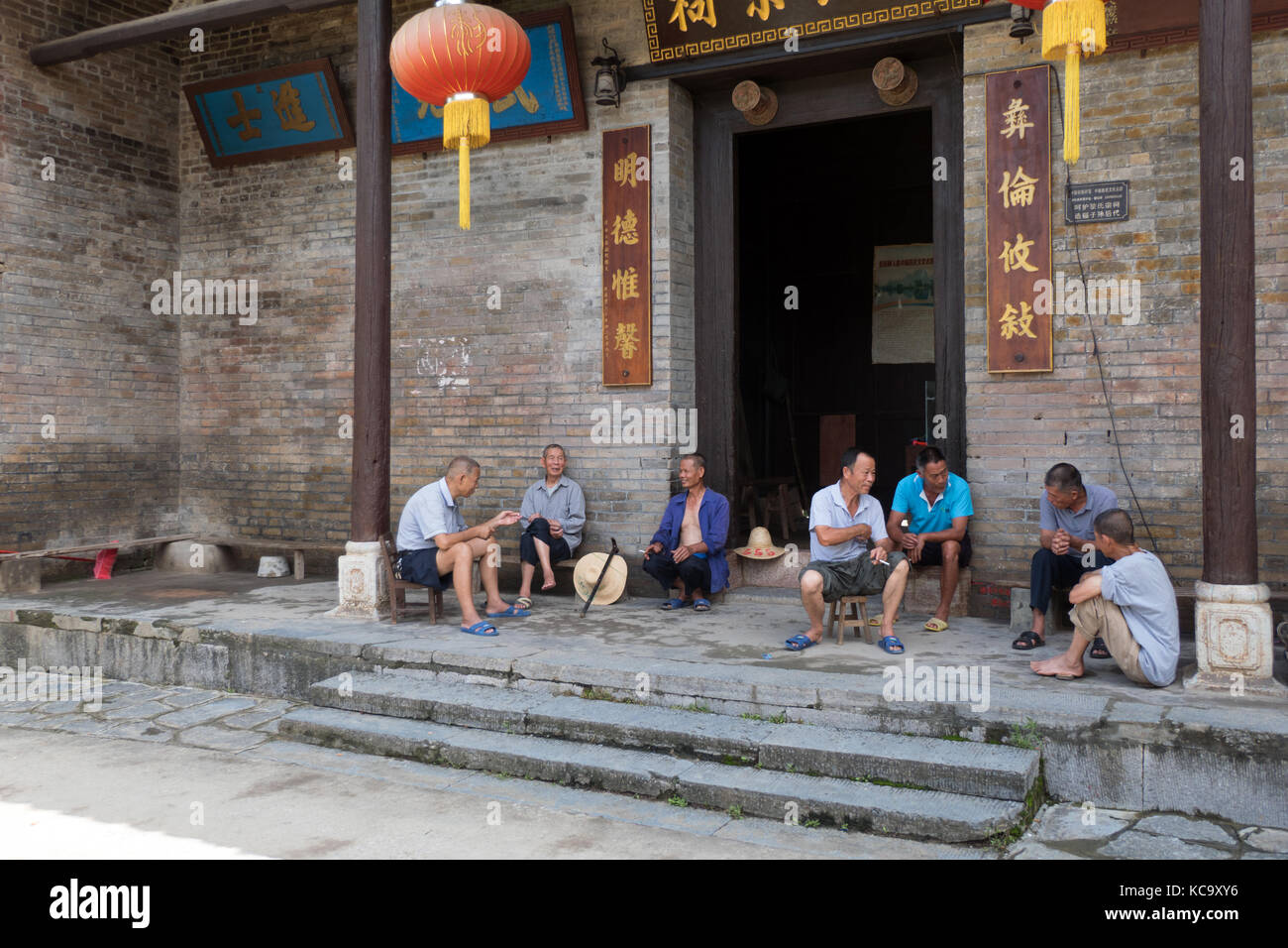 Gruppe von hochrangigen chinesischen Männer entspannen, Reden und Rauchen im Dorf jiuxian, yangshuo County, Guangxi, China, Asien. Alte Freunde Spaß mit leisu Stockfoto