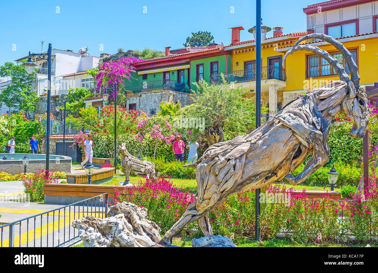 Antalya, Türkei - 12. Mai 2017: die hölzerne Ibex unter den Blumen von mermerli Park mit historischen Farbige osmanischen Stadthäusern auf dem Hintergrund, Mai Stockfoto