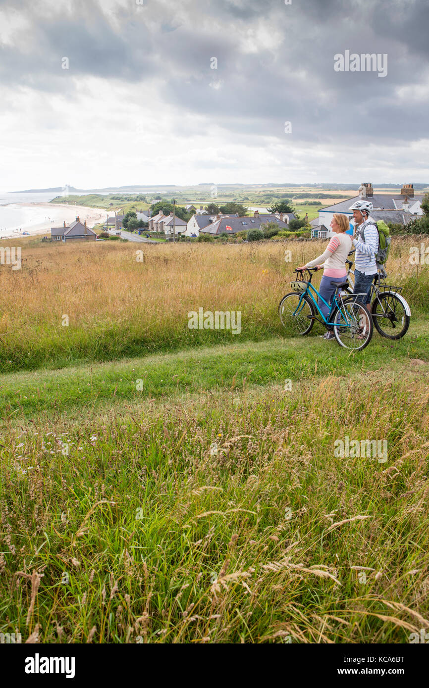 Ein paar auf den Sanddünen mit ihren Bikes gestanden sind, haben Sie gestoppt, um die Aussicht zu genießen. Stockfoto