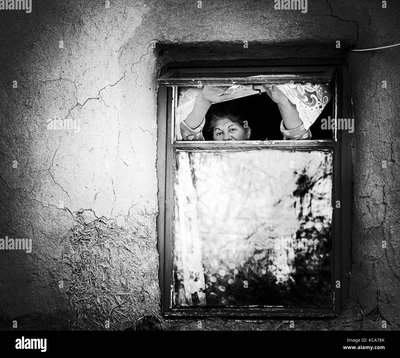 Alte Frauen warten, außerhalb suchen, über das Fenster. Stockfoto