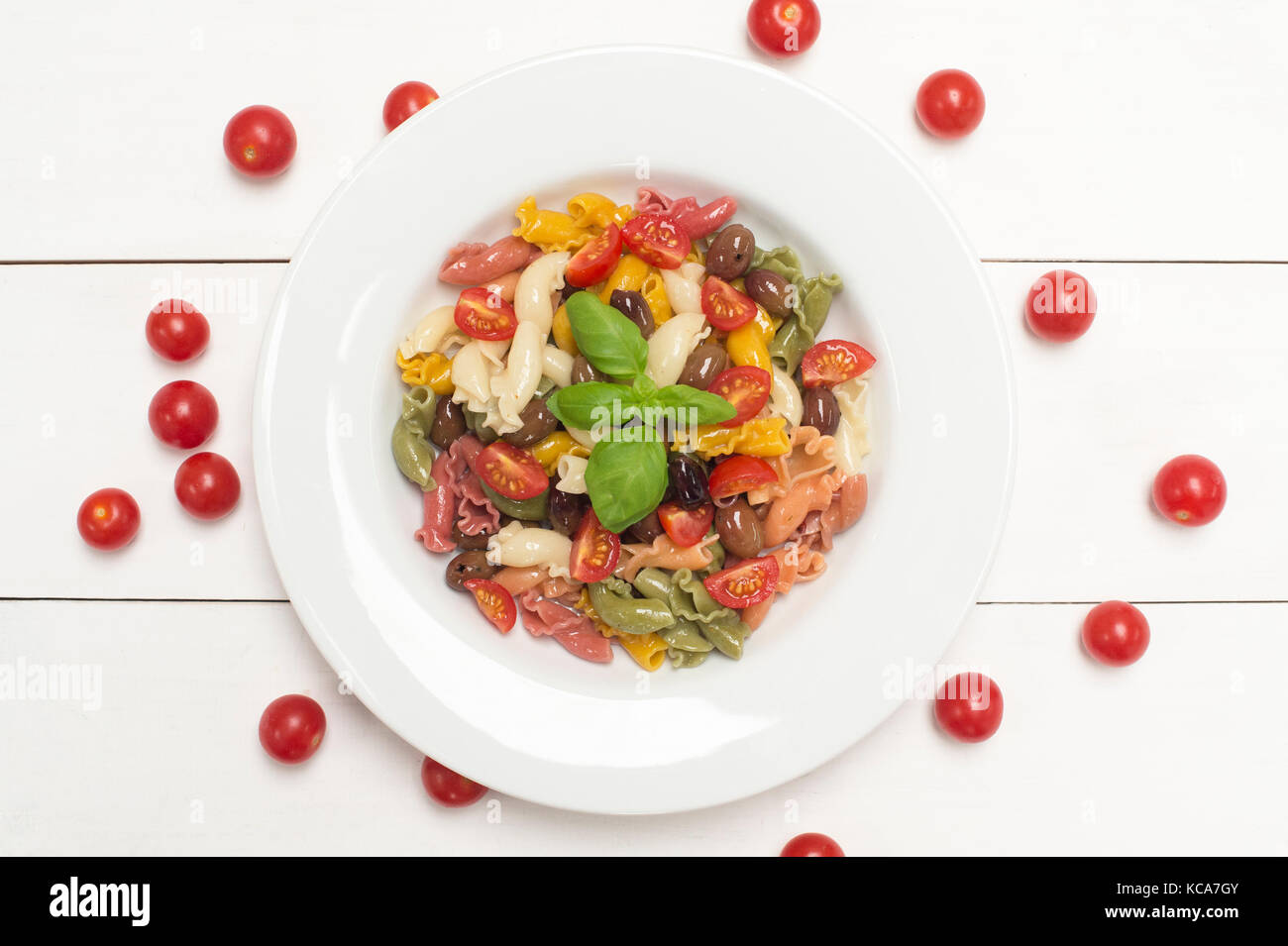 Aromatisierte Pasta, Basilikum und Tomaten auf weißem Hintergrund Stockfoto