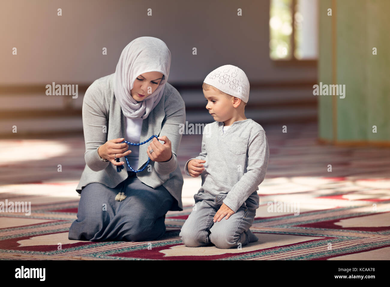Muslimische Mutter ihren Sohn beten lehren innerhalb der Moschee Stockfoto