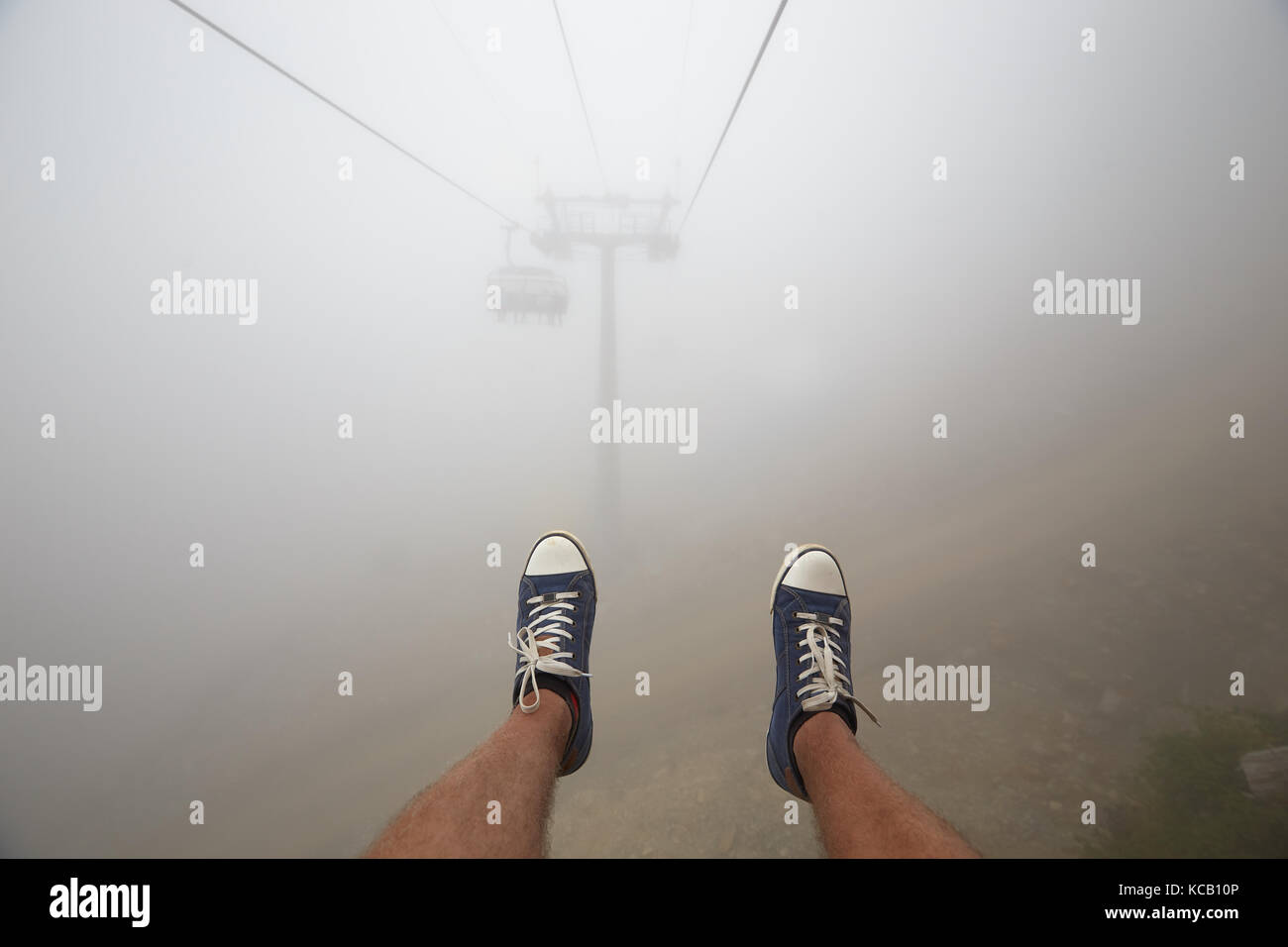 Reisende fahren Mountain Seilbahn erstreckt sich über schöne Frühherbst Berglandschaft im tiefen Nebel. first person Ansicht Stockfoto