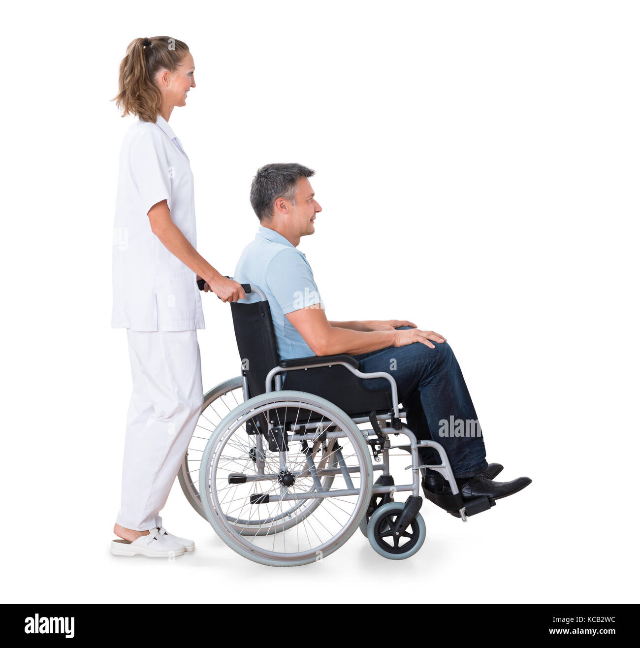 Ein weiblicher Wärter schieben Behinderte männliche Patienten im Rollstuhl vor weißem Hintergrund Stockfoto
