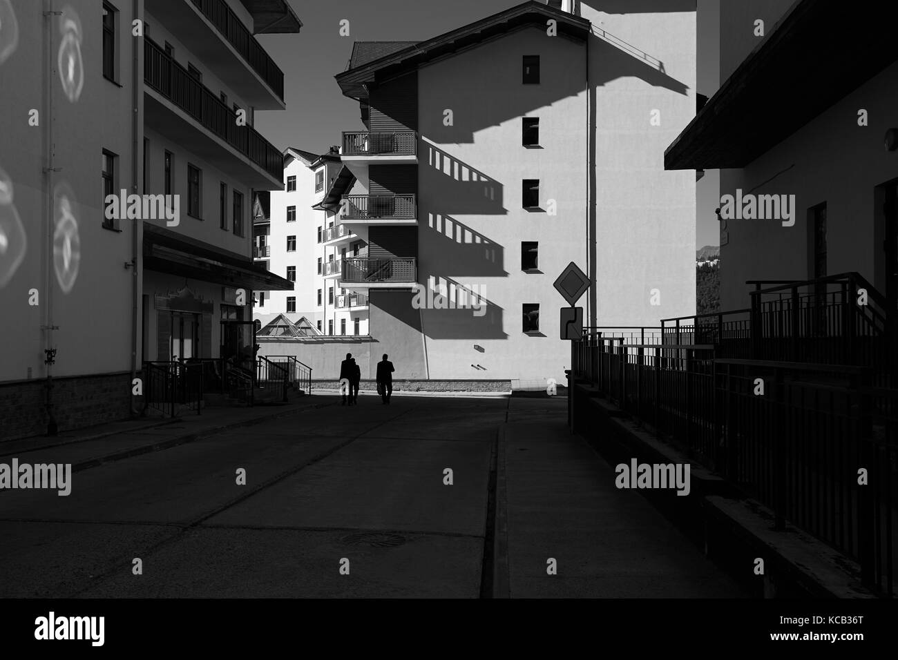 Schwarz-weiß Foto Stadt Straße mit langen Schatten Stockfoto