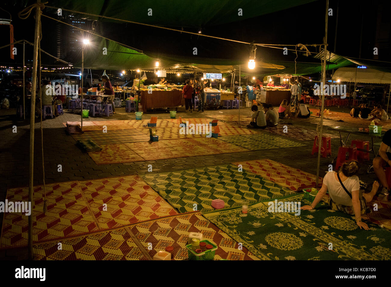 Die Street Food Bereich bei Phnom Penh Nacht Markt, wo Kunden von garküchen essen können und in einem kühlen Raum mit Teppichen und Zelt shelter Asien Speisen Stockfoto