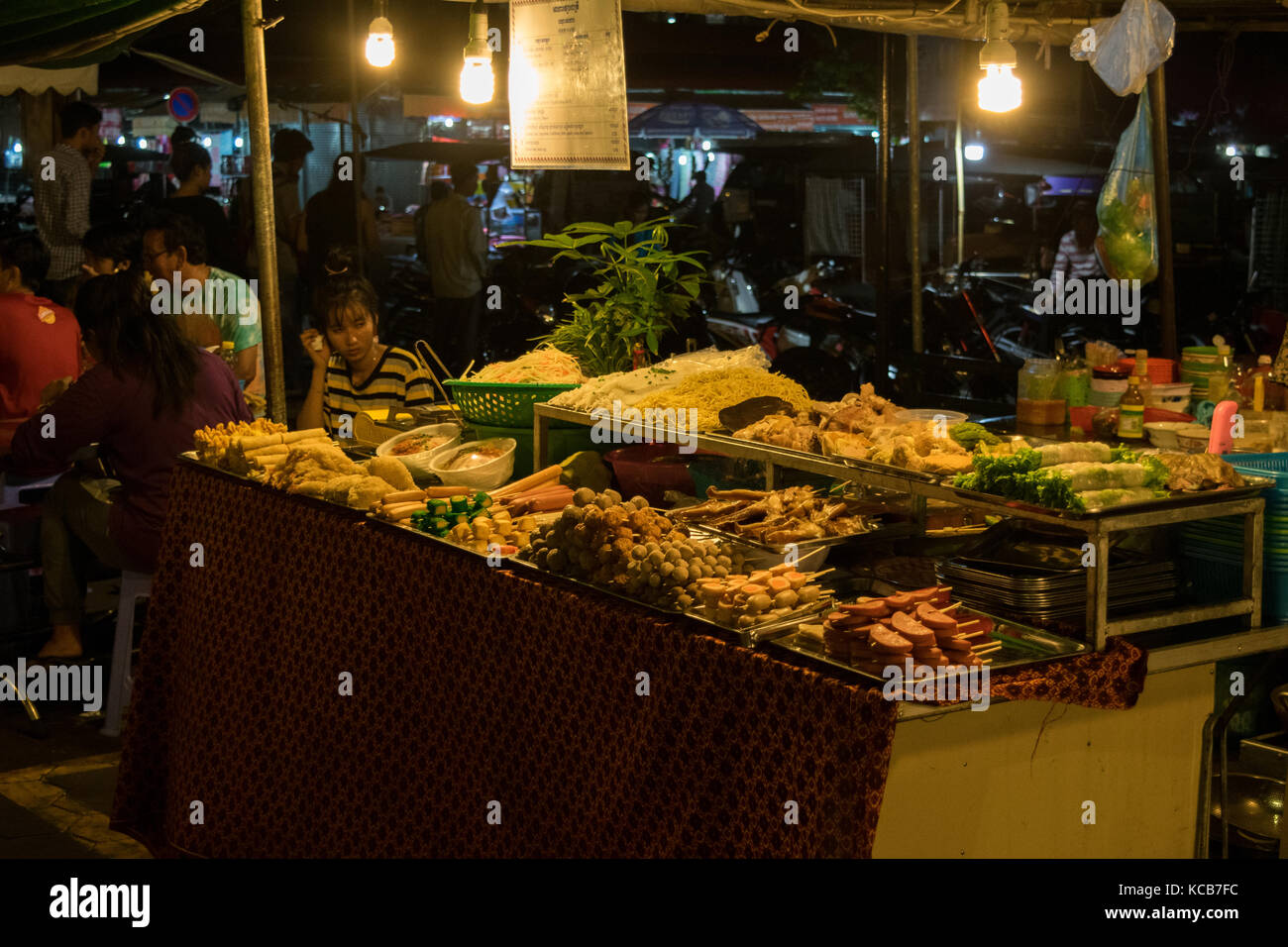 Ein asiatisches Essen Hersteller, Verkauf Straße essen im Phnom Penh Night Market, in Kambodscha. Das Essen ist meistens gebraten und billig, Experimentieren und serviert asiatische Küche. Stockfoto