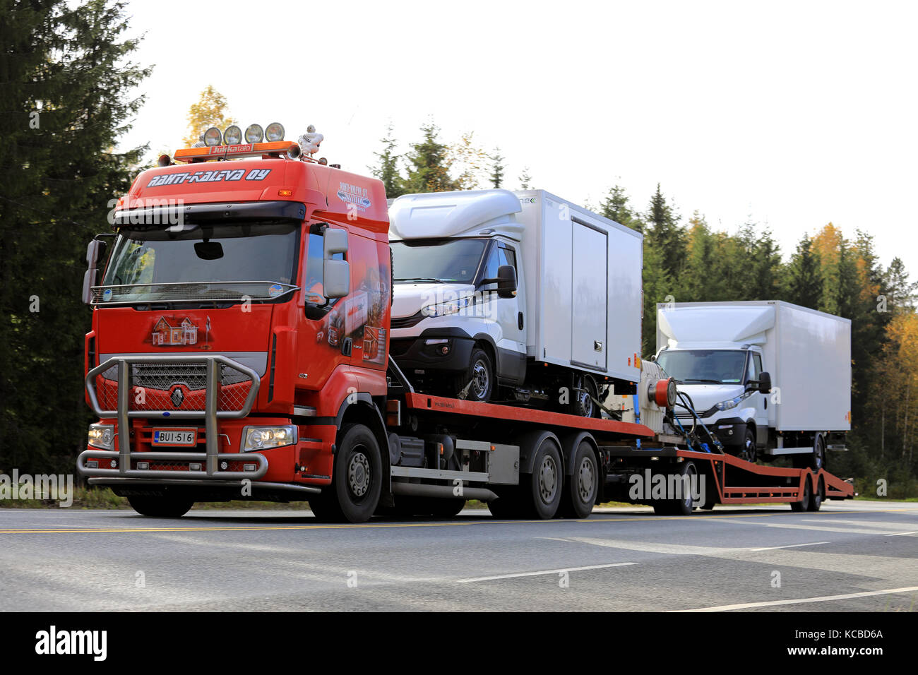 Tammela, Finnland - 29. September 2017: rote Renault Premium 450 Lkw von rahti - kaleva Oy Transporte zwei Iveco Daily Transporter entlang der Autobahn. Stockfoto