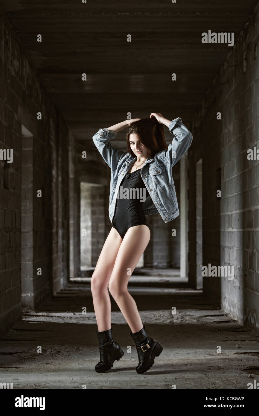 Konzept: düster, tausendjährigen. traumhaft schöne junge Mädchen mit Körper und Jeans Jacke Fotoshooting in verlassenen Konstruktion von Gebäude präsentiert t Stockfoto