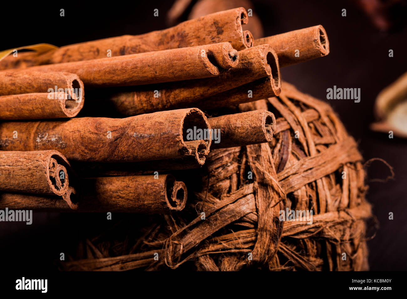 Gemahlener Zimt, Zimtstangen, mit einem Tablett mit einem Bogen auf einem farbigen Hintergrund im rustikalen Stil verbunden. Makro Foto mit selektiven Fokus. Nach oben Schließen Stockfoto