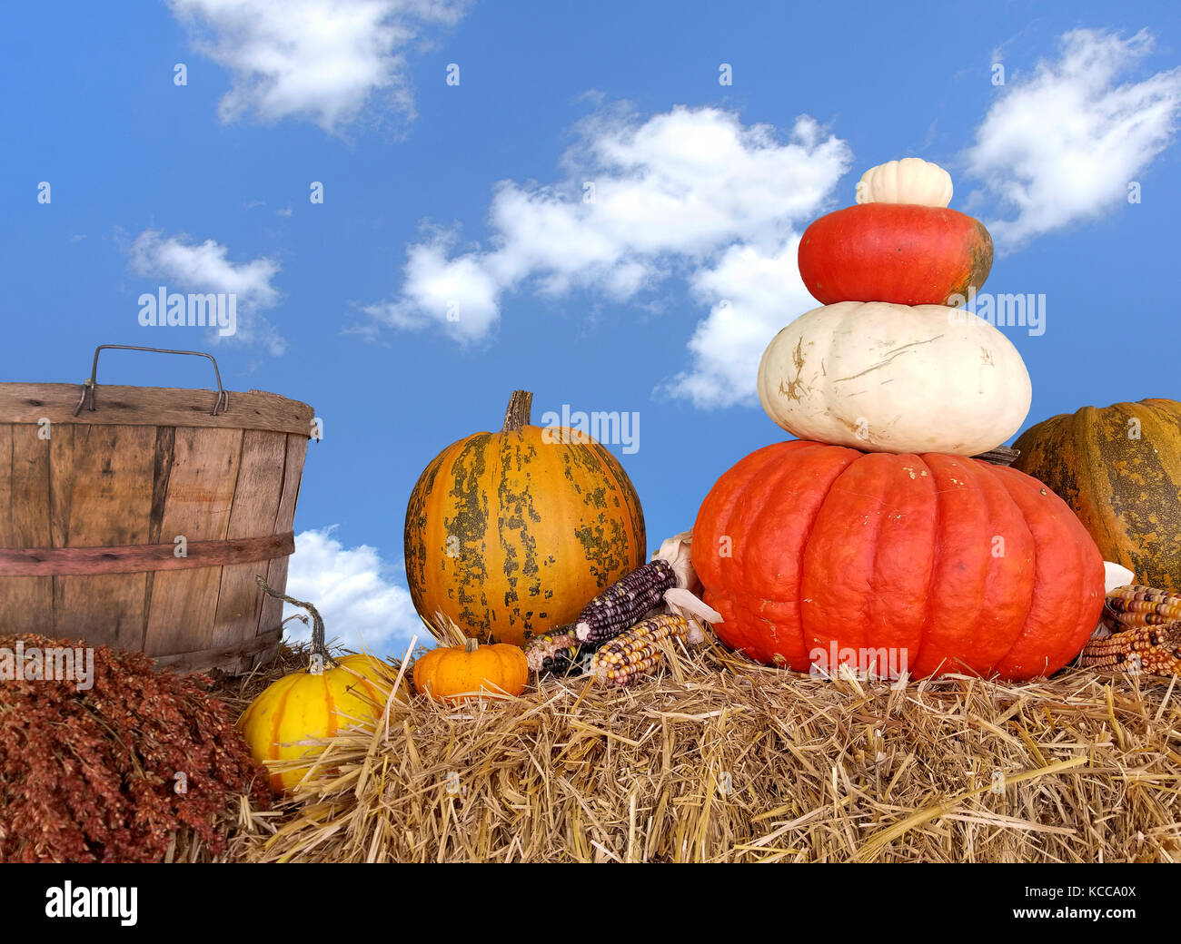 Herbst Kürbisse und Scheffel auf Heu Ballen mit blauem Himmel und Cloud Hintergrund Stockfoto