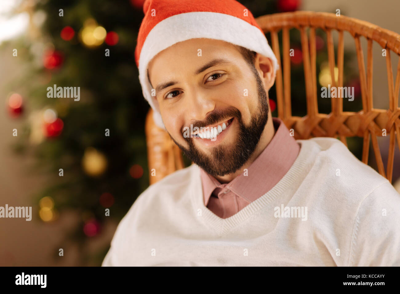 Schöner Mann in santa hut lächelnd an Kamera Stockfoto