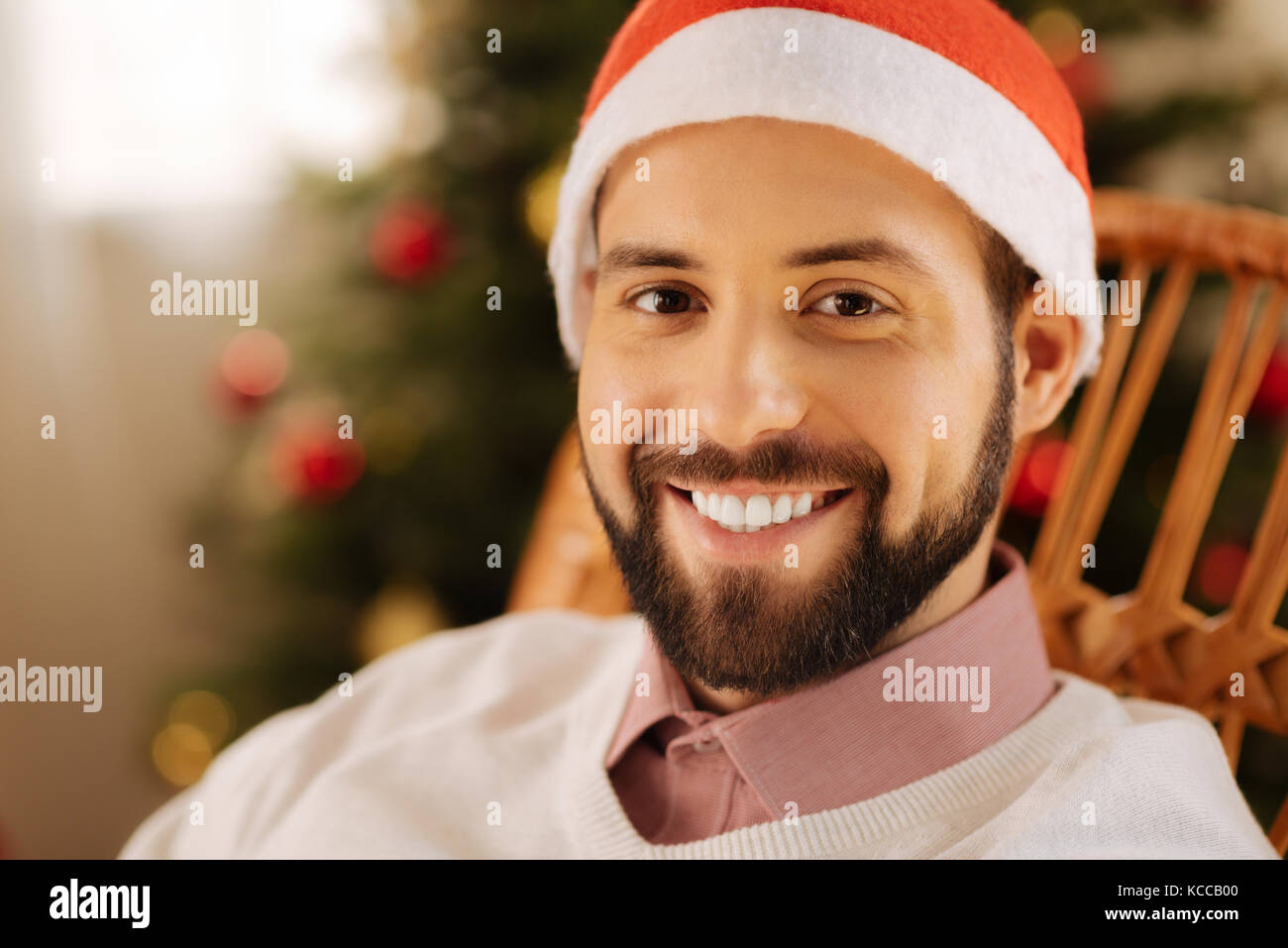 Glückliche Menschen in Santa Hut im Schaukelstuhl posing Stockfoto