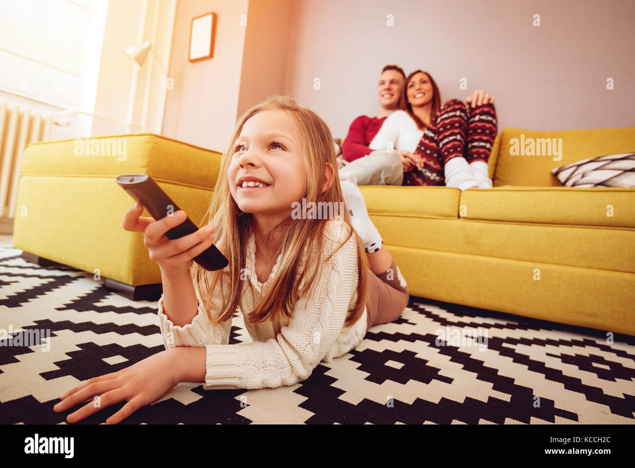 Schöne junge Familie eine Freizeitaktivität zu Hause. Sie sehen einen Tv. Selektive konzentrieren. Stockfoto