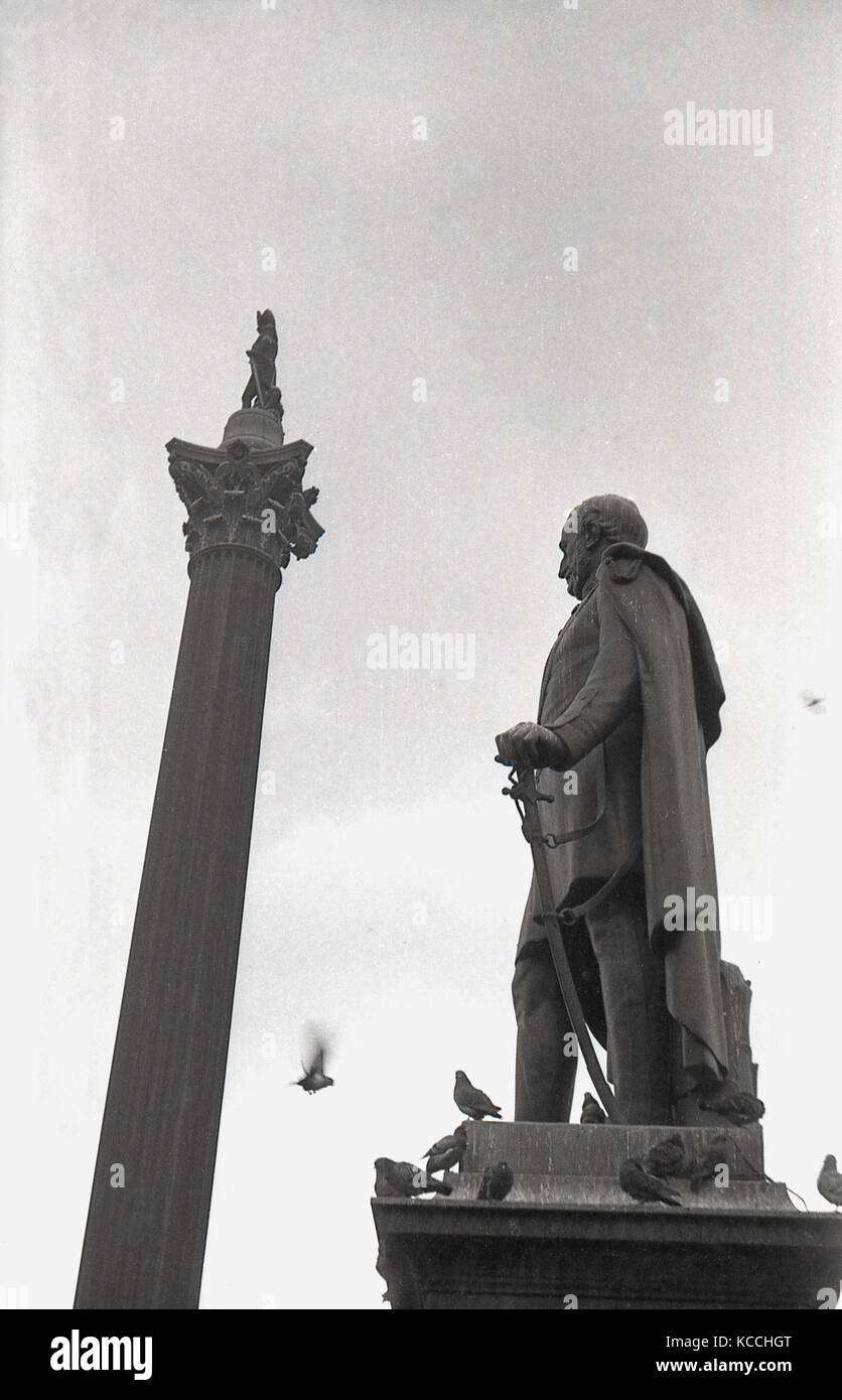 Historisches Bild aus den 1940er Jahren, das die berühmte Nelson-Säule auf dem Londoner Trafalgar Square zeigt, mit der Statue des Generalmajors Sir Henry Havelock auf einem Sockel, mit Tauben, auf dem Sockel. Stockfoto