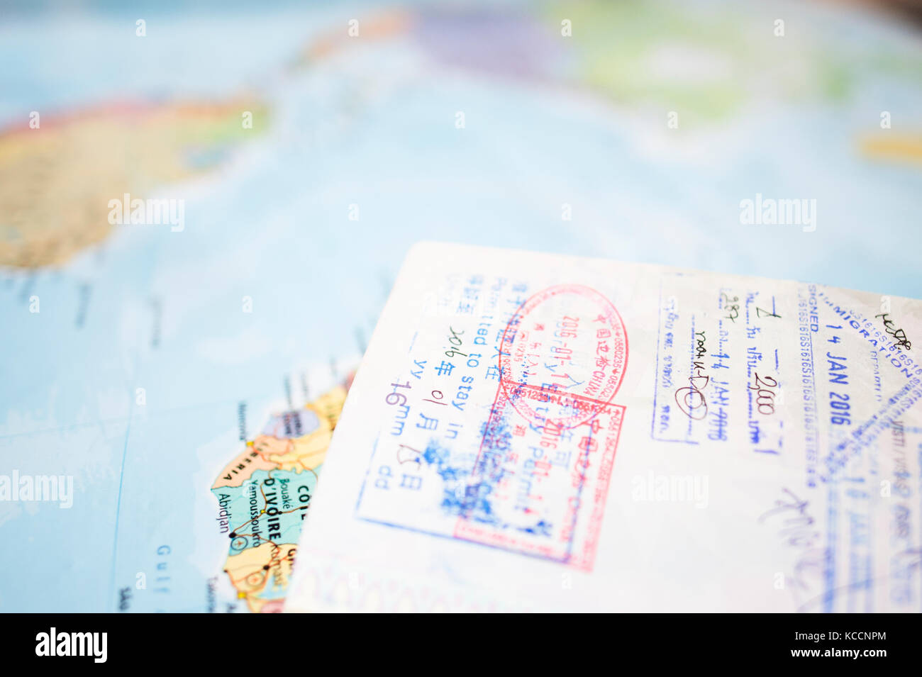 (Selektive Fokus) einen Reisepass mit Stempel ist auf eine unscharfe geographische Karte der Welt. Stockfoto