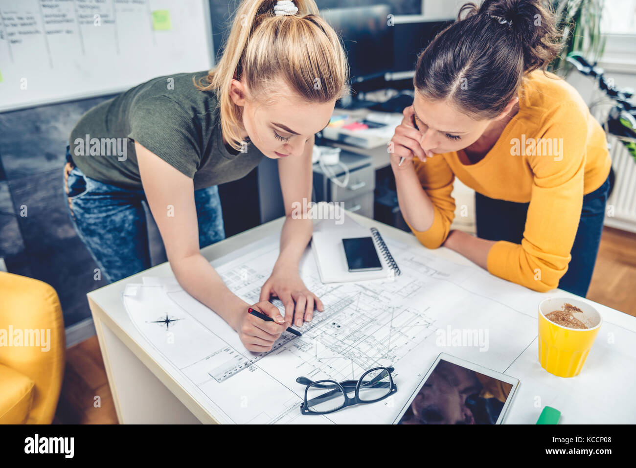 Zwei business Frau im Büro Kontrolle Blueprints auf dem Schreibtisch Stockfoto