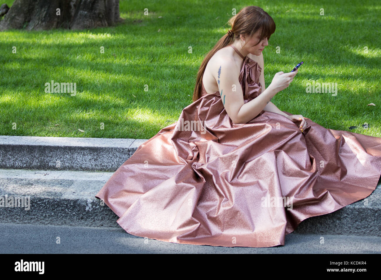 Mailand, Italien - September 22, 2017: Das Modell trägt Kleid einer Frau wie Aschenputtel, glitzernde Rosa und verwendet Ihr Smartphone während der armani Parade, pho Stockfoto