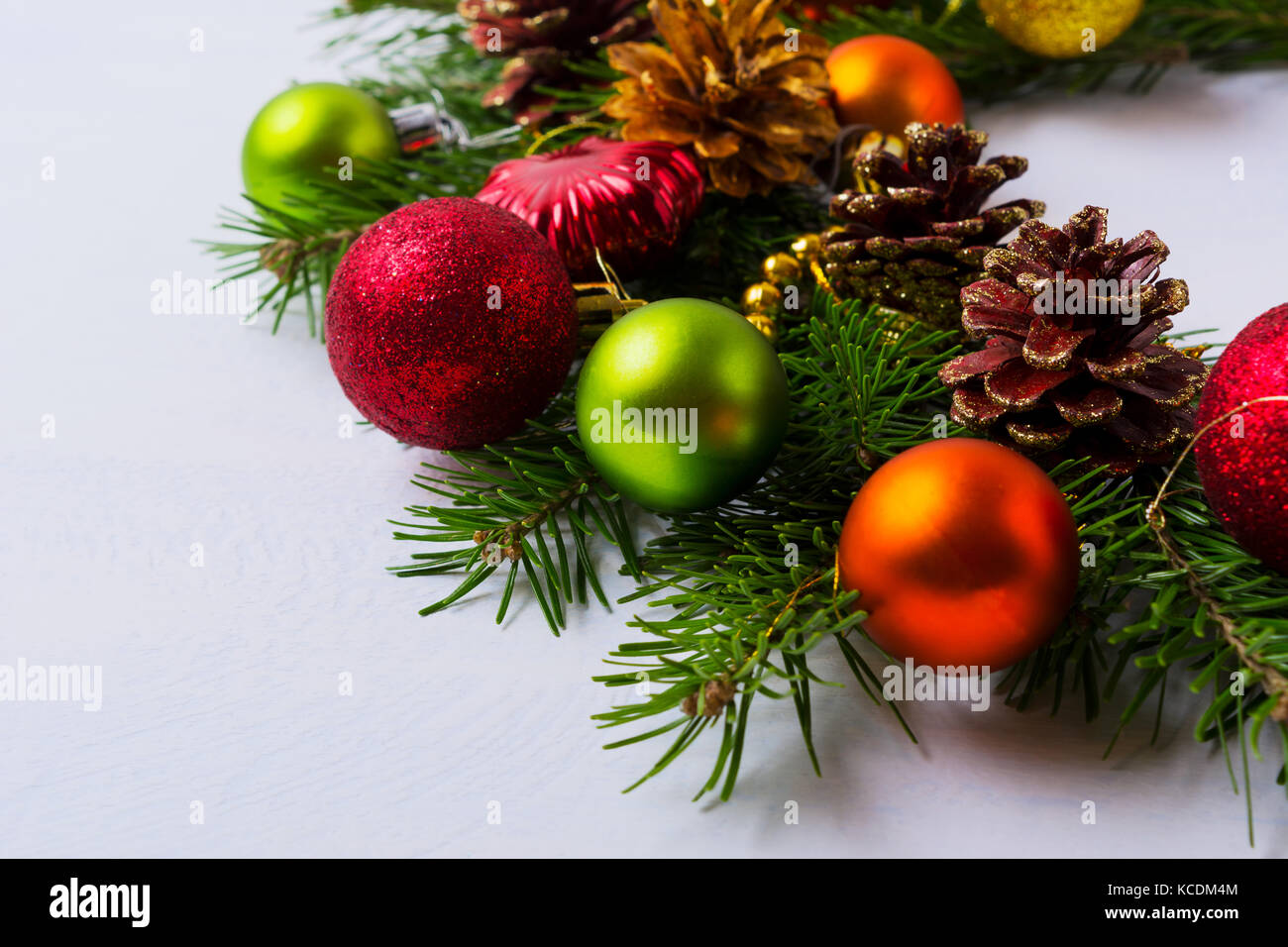 Weihnachten Kranz mit Rot, Orange, Grün und goldenen Ornamenten dekoriert Tannenzapfen. Begrüßung Hintergrund. Stockfoto