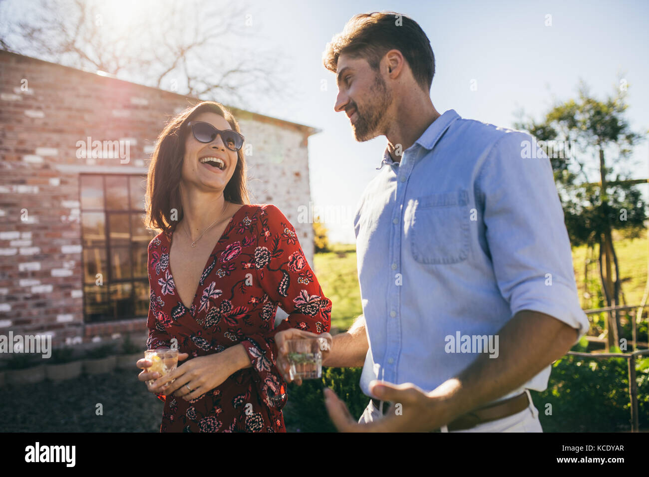 Multi-ethnischen tausendjährigen Paar gehend im Freien und Chatten. Der Mann und die Frau bei einem Getränk im Freien. Stockfoto