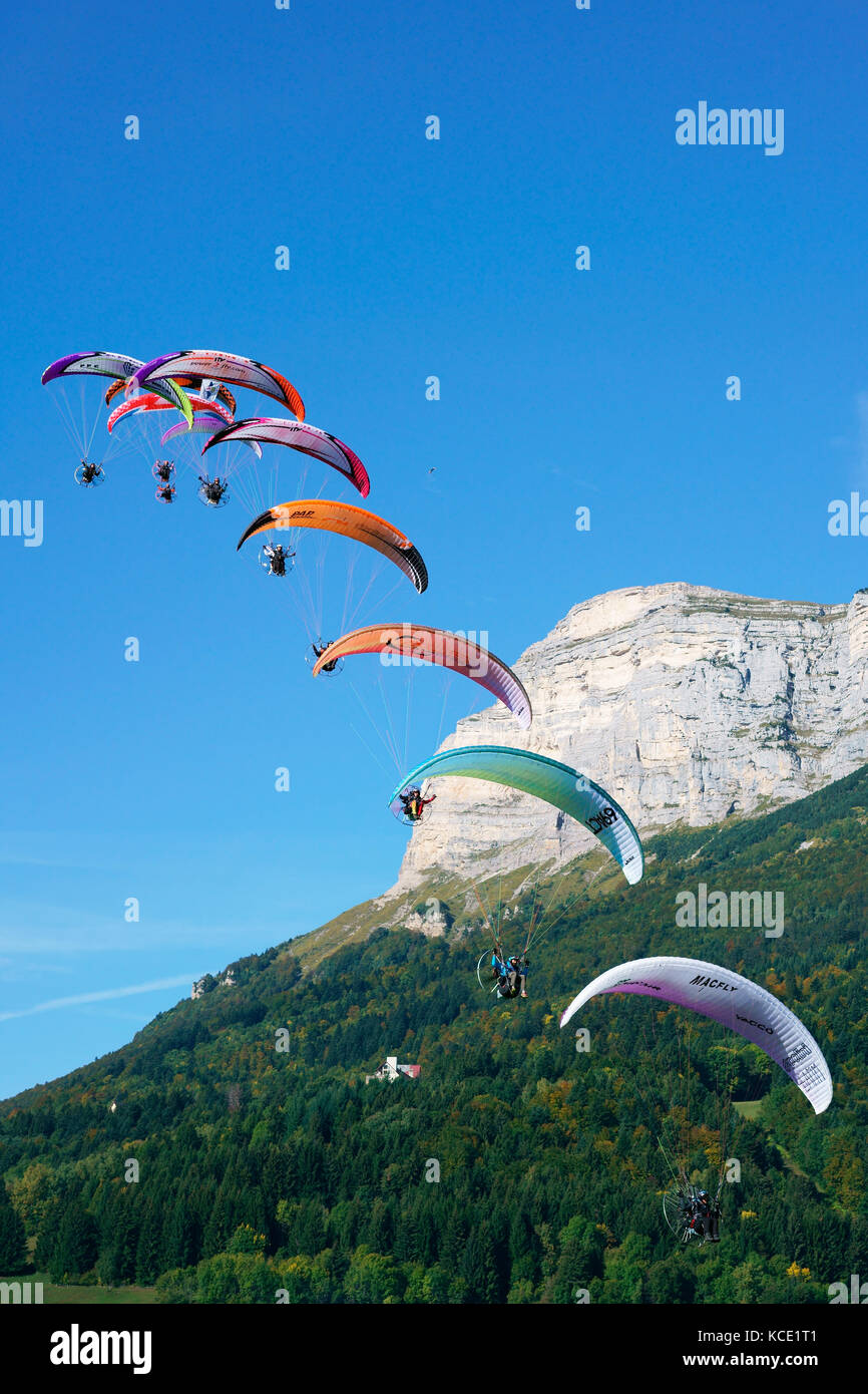 Flotte von neun Sanitätern, die beim Coupe Icare Event 2017 fliegen, Dent de Crolles (2062m m ü.d.M.) im Hintergrund. Saint-Hilaire du Touvet, Isère, Frankreich. Stockfoto