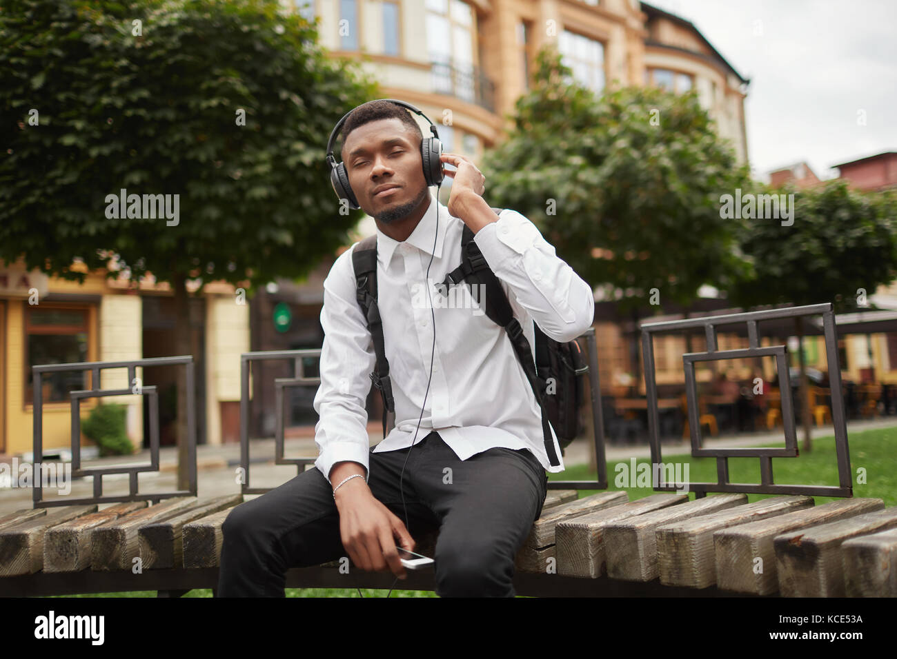 Afrikanischer Mann ruht auf der Werkbank und das Hören von Musik über Kopfhörer. Stockfoto