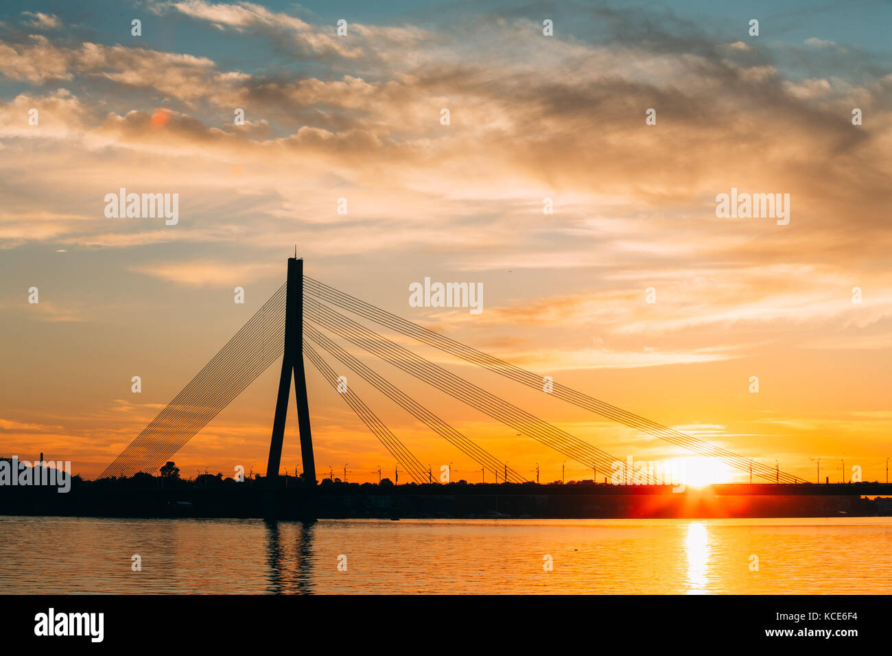Riga, Lettland. malerische Aussicht auf vansu Schrägseilbrücke über den Fluss Daugava, westlichen Dwina in hellen Sonnenuntergang bzw. Sonnenaufgang Stockfoto