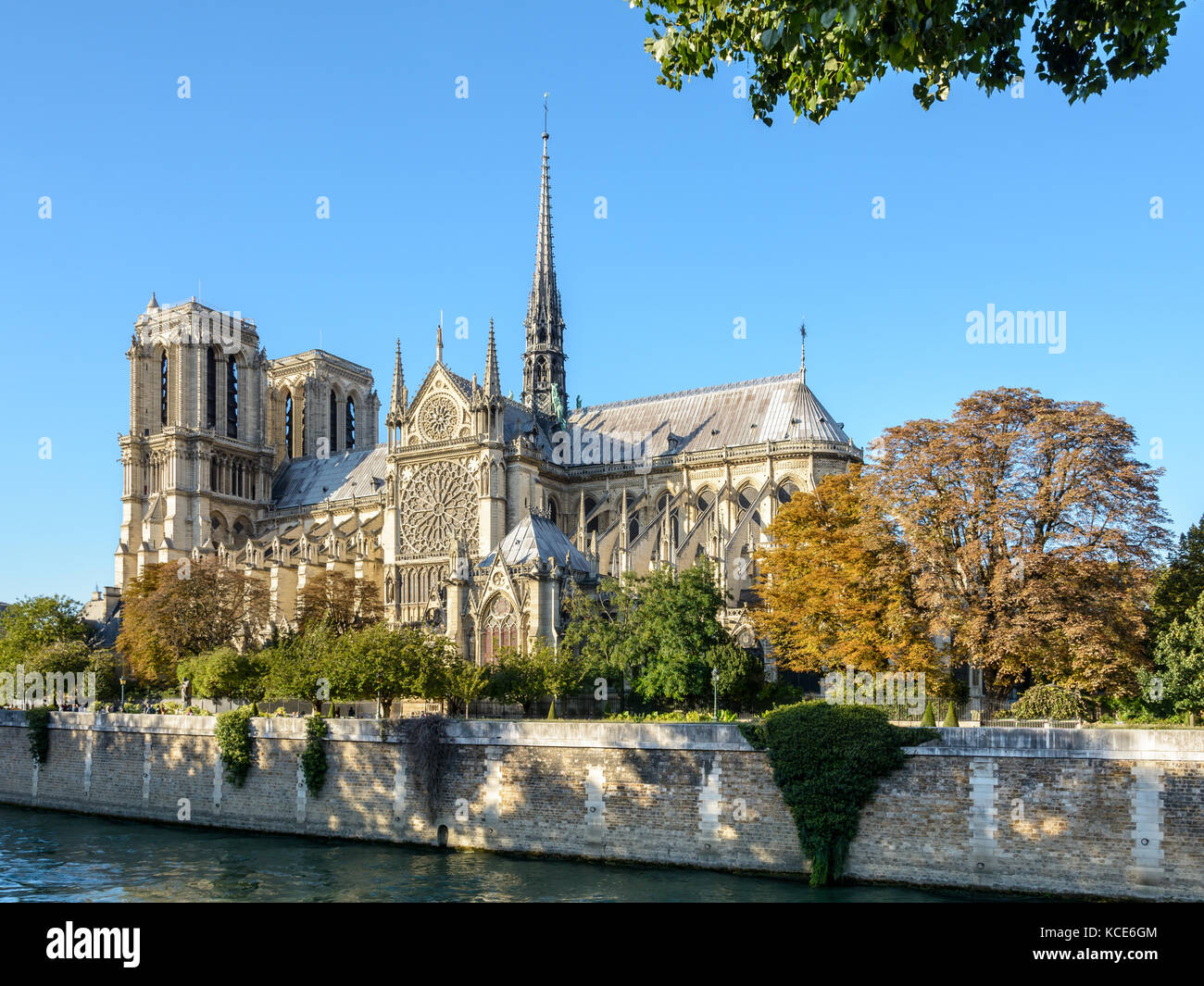 Drei Viertel auf der südlichen Seite der Kathedrale Notre-Dame de Paris von einem sonnigen Abend Anfang Herbst mit dem Fluss Seine in der foreg Stockfoto
