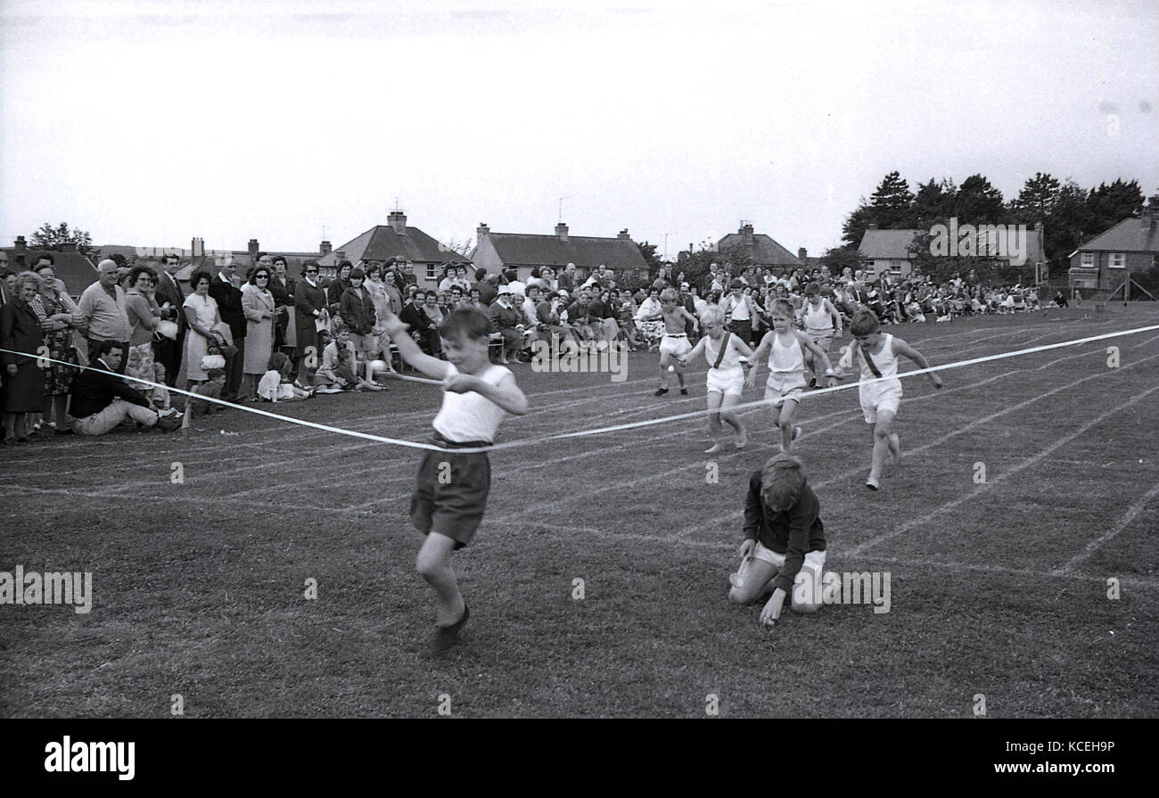1960, historische Bild von kleinen Jungen, die sich in einem Ei-und-löffel Rennen an eine Grundschule Sport Tag. Dorchester, England, UK. Stockfoto