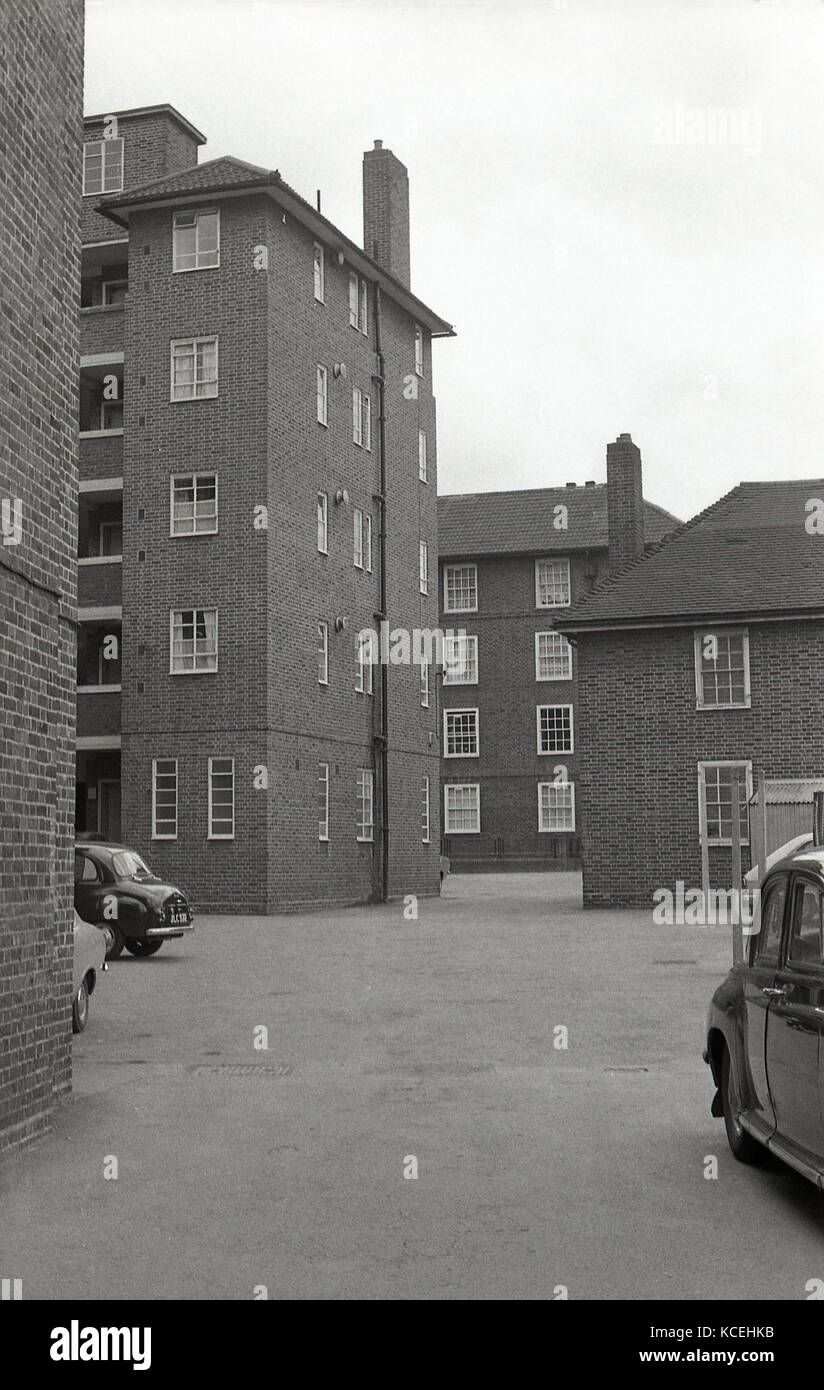 1960, historische, mehrere Autos der Ära abgestellt - Straße, an der Rückseite eines Blocks von Gemeindewohnungen, London, England. Stockfoto