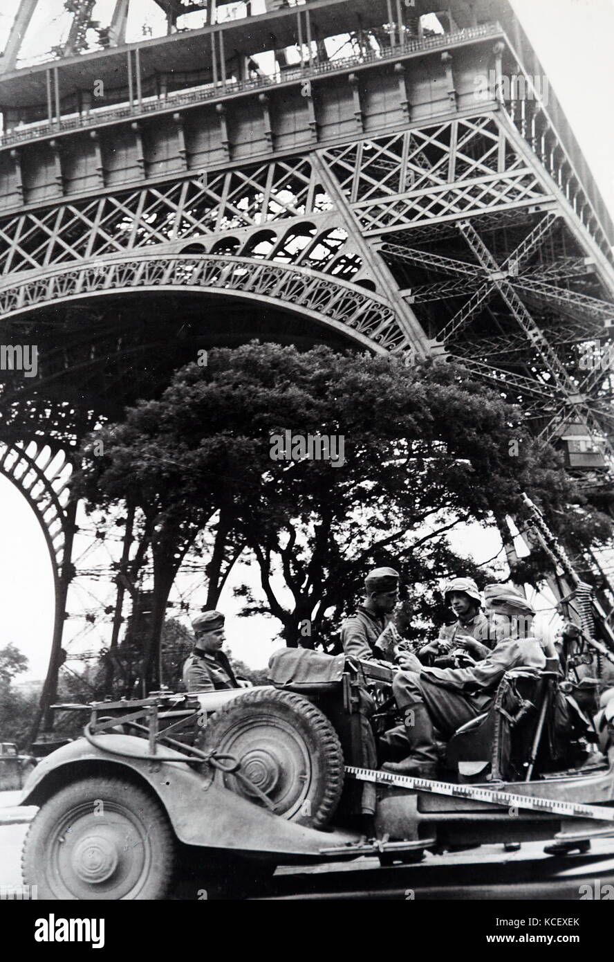 Weltkrieg: Deutsche Soldaten sitzen in einem Fahrzeug unter dem Eiffelturm, wie Sie Paris, während der Invasion von Frankreich 1940 besetzen. Vom 20. Jahrhundert Stockfoto